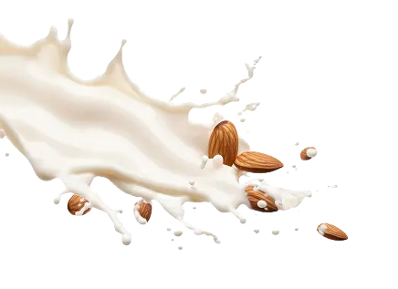 Salpicadura de leche de almendra hecha con la ordeñadora vegana, con almendras enteras esparcidas.
