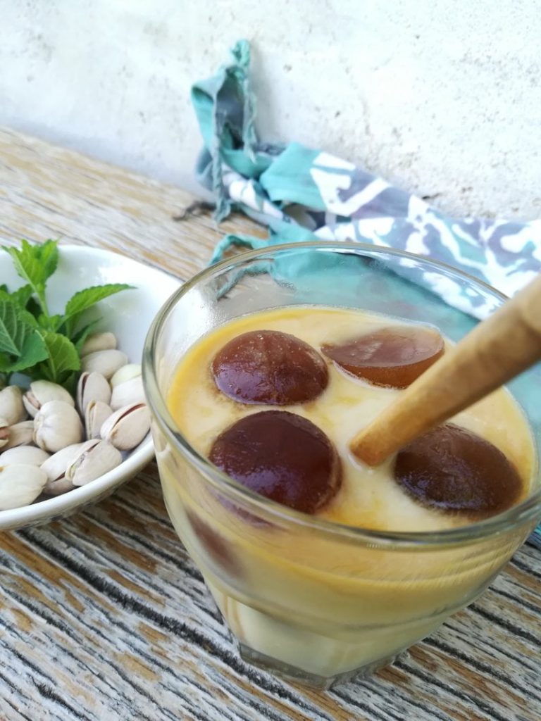 vaso de cristal con cubitos de café y leche de avena y pistacho verde clara